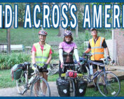 Three people standing with their touring bikes