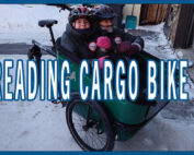 Two small children in a front bucket-style cargo trike