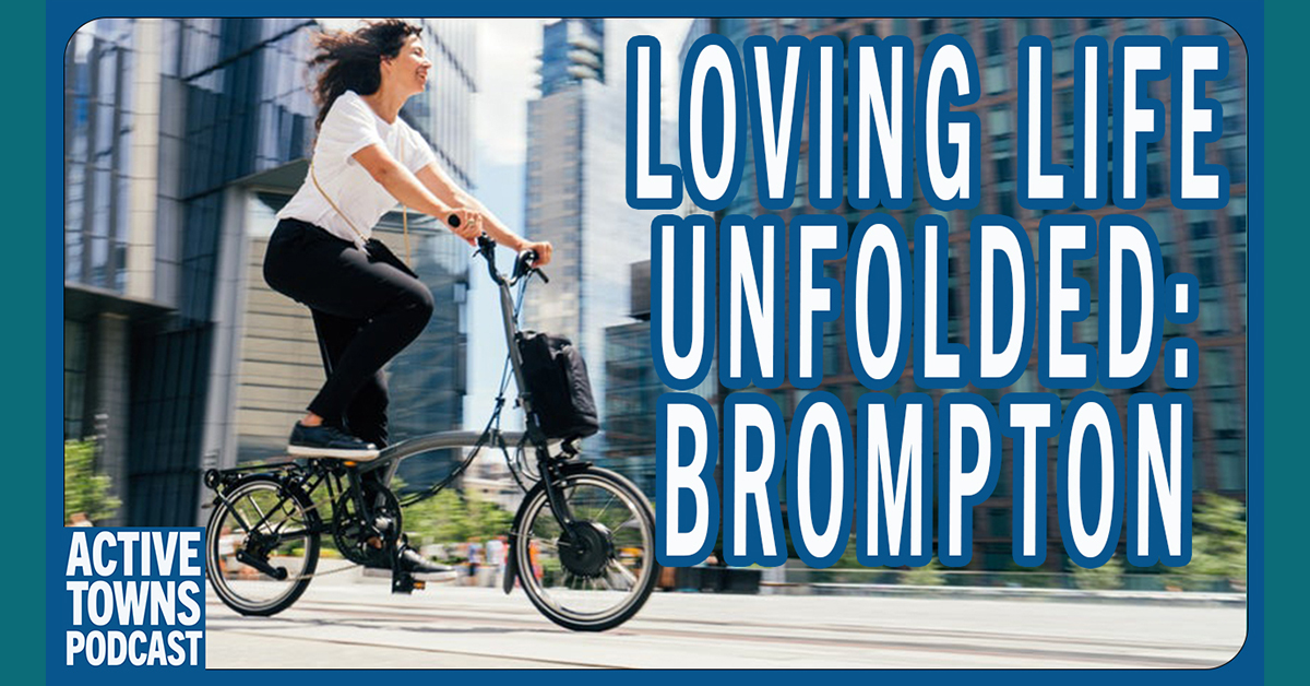 A woman riding a Brompton folding bike in her everyday clothes in a city setting