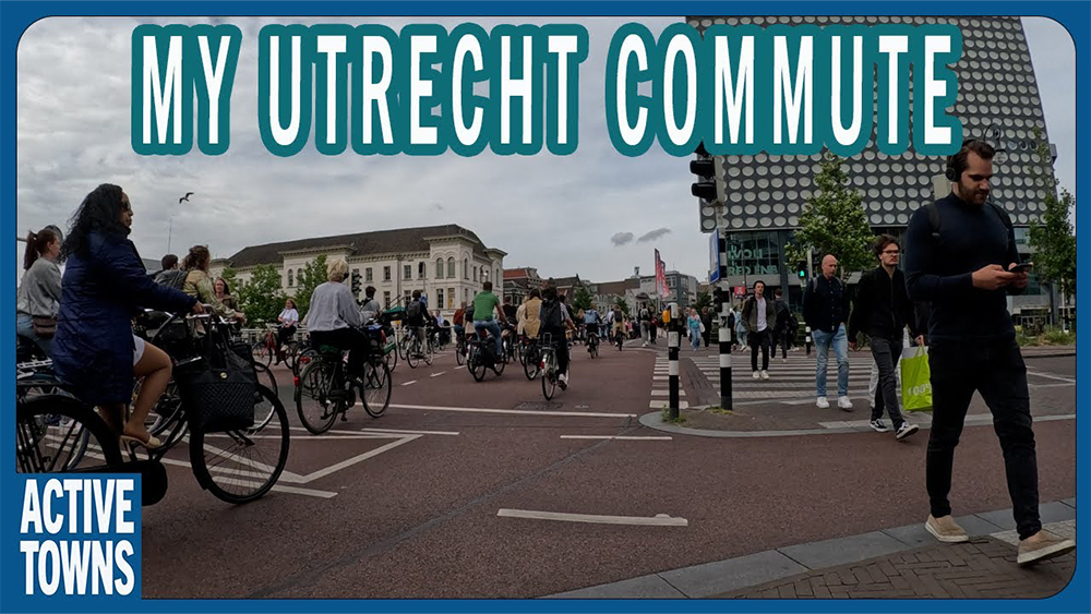 Busy Utrecht street with people walking, biking and using public transit