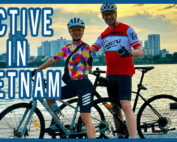 Dieter and Grace giving a thumbs up sign with their bicycles overlooking the water