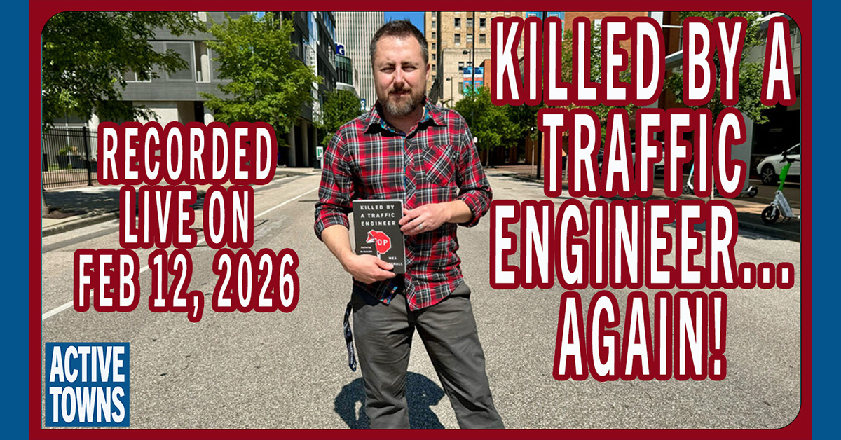 Wes holding a copy of his book in the middle of the street